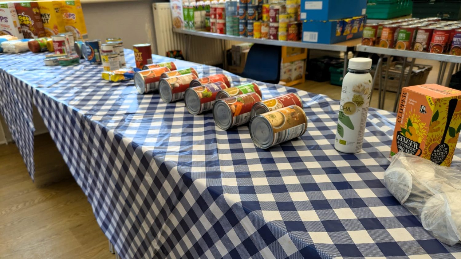 Members can choose from the table of cupboard staples, cereal, long life milk and tins, displayed neatly on a chequered table cloth.